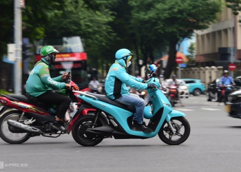 TP HCM sẽ làm gì để chuyển 400.000 xe xăng sang xe điện?. Tài xế hai hãng xe sử dụng xe xăng và xe điện chạy trên đường trung tâm TP HCM. Ảnh: Thanh Tùng