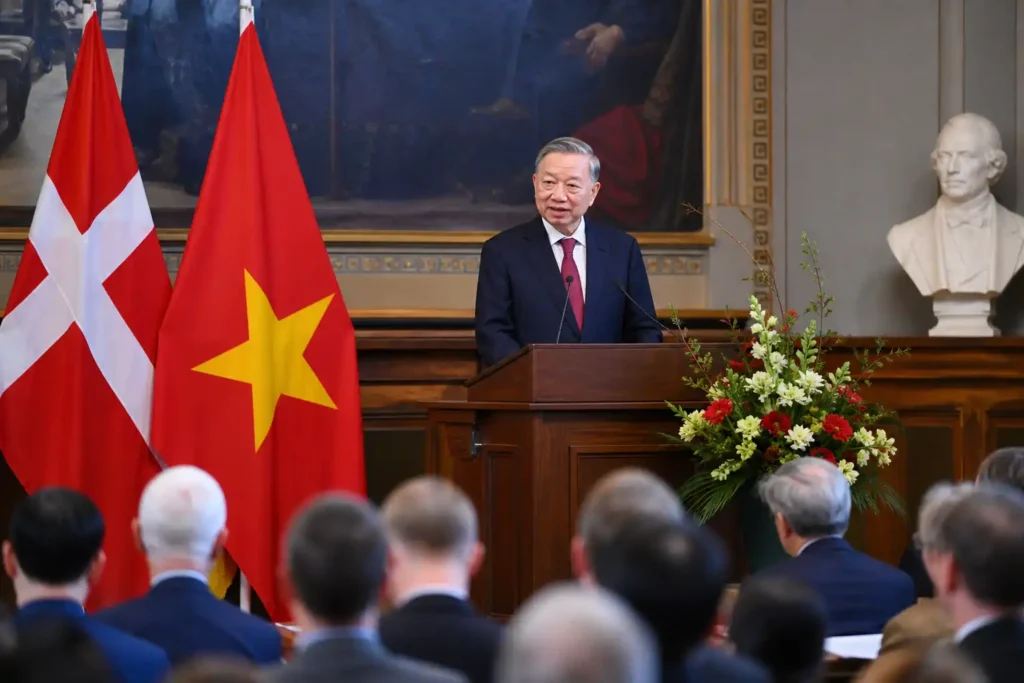 Chinese and Danish officials at a podium with national flags during a formal diplomatic event